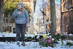 A protester stands next to a makeshift memorial honoring the victim of a fatal shooting involving federal law enforcement agents, near the scene in Minneapolis, Wednesday, Jan. 7, 2026.