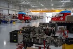 Semi-trucks and engine parts sit in a Daimler facility during a tour of their North American headquarters in Portland, Ore., on July 23, 2026.