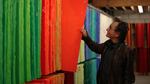 Bullseye Glass co-founder Dan Schwoerer pulls out one of the orange glass sheets his company makes using cadmium.