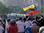 Police block protesters during demonstrations against the official election results declaring President Nicolas Maduro's reelection, the day after the vote at a highway in Caracas, Venezuela, Monday, July 29, 2024. 