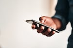 Photo of a man holding his cellphone.