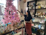 Lisa Stanger, owner of Blackthorn Mercantile, straightens an ornament on her store's vintage winter holiday tree in Portland, Ore. on Nov. 21, 2023. Blackthorn Mercantile is participating in Win Big, an effort to support local businesses during the holiday shopping season.