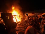 Palestinians react to fire from an Israeli strike that hit a tent area in the courtyard of Al Aqsa Martyrs hospital in Deir al Balah, Gaza Strip, on Sunday. The strike killed several people including a woman and injured others, health officials confirmed.