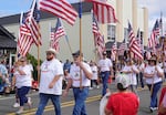 Dozens cary flags during the Fourth of July parade at the 90th St. Paul Rodeo. Nearly every resident of St. Paul volunteers in some way to put on the rodeo each year.