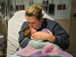 Caitlyn Houston kisses her seven-week-old daughter, Parker, as they wait in the ER for a hospital bed to open up on Dec. 7 at Corewell Health Helen DeVos Children's Hospital in Grand Rapids, Michigan. "There's so many kids in here that they have to take the ones that are really bad," Houston said.