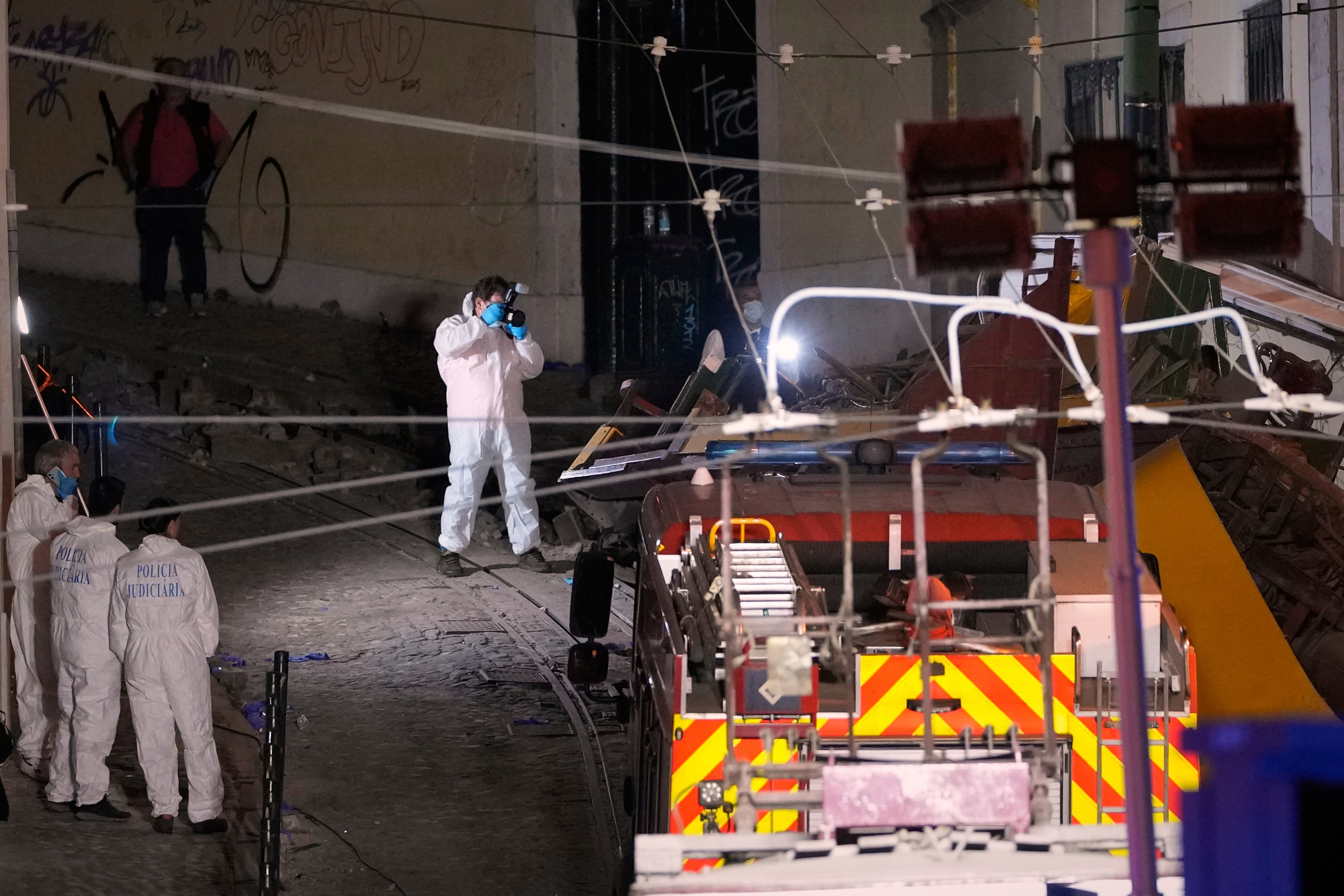 Members of the judicial police work at the site of a derailed electric streetcar in Lisbon, Portugal, Wednesday, Sept. 3, 2025.