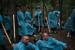 Ukrainian investigators gather while they exhume bodies from a mass grave site in Izium on Friday.