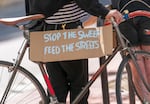 FILE: A sign on the bike of a person attending a rally at Pioneer Courthouse in Portland, Ore., April 22, 2024, organized by Stop The Sweeps PDX. 