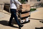 A worker wheels out the belongings of a fellow employee who was dismissed, outside of the Mary E. Switzer Federal Office Building, which houses offices for the US Department of Health and Human Services in Washington, DC, on Tuesday.