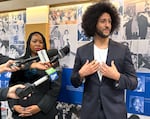 Colin Kaepernick, standing next to Kimberlee Armstrong, speaks to members of the press after a speech at Benson Polytechnic High School.