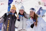 United States' Breezy Johnson, center, gold medal in an alpine ski women's downhill race, silver medalist Germany's Emma Aicher, left, and bronze medalist Italy's Sofia Goggia, show their medals, at the 2026 Winter Olympics, in Cortina d'Ampezzo, Italy, Sunday, Feb. 8, 2026.