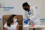 Michelle Chester, director of employee health services at Northwell Health, right, shows the Moderna COVID-19 vaccine to Arlene Ramirez, director of patient care at Long Island Jewish Valley Stream hospital, before administering the vaccine to her on Monday, Dec. 21, 2020, in Valley Stream, N.Y.