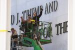 Workers react to the media after updating signage outside the Kennedy Center on Dec. 19, 2025, in Washington, D.C.