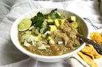 A warm bowl of creamy chicken and white bean chili with all the accoutrement.