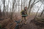 A Ukrainian serviceman of the Da Vinci Wolves Battalion carries an artillery shell before firing toward Russian positions at the front line in eastern Ukraine, on Nov. 28.