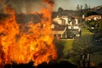 Flames rise as the Palisades Fire advances on homes in the Pacific Palisades neighborhood of Los Angeles.