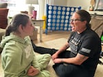 Emma Lenover, left, works through a literacy lesson at home with special education teacher Sarah Elston. Emma loves these visits and, on this day, waited anxiously at the picture window for Elston to arrive.