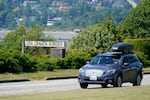 A vehicle drives past a sign that reads "USA-Canada border"