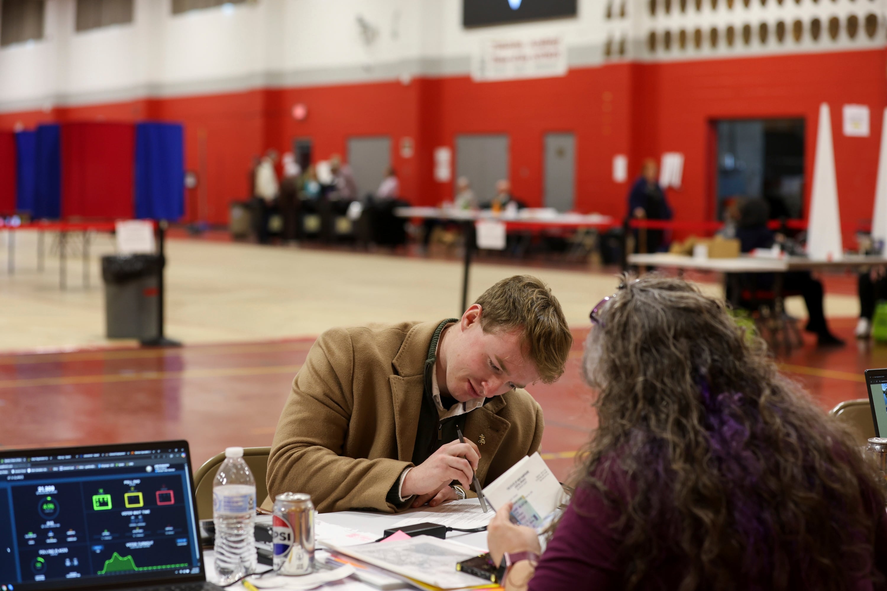 A voter registers to vote in Derry, N.H., on March 11. New Hampshire's March elections were the first test of the state's new proof-of-citizenship law.