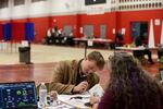 A voter registers to vote in Derry, N.H., on March 11. New Hampshire's March elections were the first test of the state's new proof-of-citizenship law.