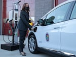 Vice President Kamala Harris charges an electric vehicle in Brandywine, Md., on Dec. 13, 2021. The Biden administration has a plan to build a network of chargers across the country.