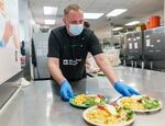 Volunteer Brendan Shields serves up hot meals. Shields is also part of the residential program offered by Blanchet House.