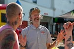 Thor Drake, center, founder of One Moto Cafe in Portland, Ore., smiles while talking to visitors at the cafe's grand opening party on July 26, 2024. One Moto Cafe, a motorcycle-themed cafe, was formerly known as See See Motor Coffee Co. Drake says, "We didn't have an official launch party the first time around. So this is kind of a party for both."