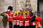 The coffin of Queen Elizabeth II, draped in a Royal Standard and adorned with the Imperial State Crown and the Sovereign's orb and sceptre is taken into Westminster Abbey.