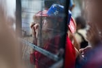 At one of the perimeter fences, Jan Servais of Montgomery, Ala., watches a monitor showing the race.
