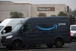An Amazon Prime delivery van sits parked near a Walmart store in California.