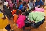 Sudanese children scrape leftover food from an empty pot that was distributed in al-Rahmaniyah camp for displaced people, near the city of El-Obeid on July 7, 2026.