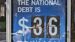 A National Debt Clock billboard display shows the United States gross national debt and each American family's share of the debt in Washington, DC, on December 30, 2024. The Congressional Budget Office has stated that the U.S. national debt is poised to top $56 trillion by 2034, as rising spending and interest expenses outpace tax revenues. The mounting costs of Social Security and Medicare continue to weigh on the nation's finances, along with rising interest rates, which have made it more costly for the federal government to borrow huge sums of money. (Photo by ROBERTO SCHMIDT / AFP) (Photo by ROBERTO SCHMIDT/AFP via Getty Images)