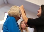 Molly Washington, NAYA board chair, gifts a necklace to Reverand Solveig Nilsen-Goodin. The organization gave gifts to the key parties involved.