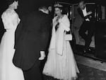 March 23, 1954: Queen Elizabeth II, followed by the Duke of Edinburgh, wearing formal dress as they are greeted on their arrival at Parliament House for the State Banquet in Australia.