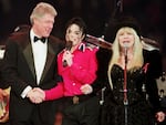 LANDOVER, UNITED STATES:  US President Bill Clinton (L) shakes hands with singer Michael Jackson (C) as singer Stevie Nicks sings during inauguration festivities in Landover, Maryland. (Photo credit should read AFP/AFP via Getty Images)