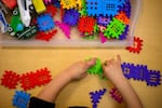 A child plays with colorful interlocking toys.