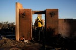 Apple Valley Fire District firefighter Wyatt Cortez walks through a destroyed house as he puts out hotspots from the Palisades Fire in the Pacific Palisades neighborhood of Los Angeles, Monday, Jan. 13, 2025.