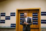 In this photo, Hakeem Jeffries, wearing a suit, stands in a room as he speaks to campaign volunteers for Rep. Susan Wild. Behind him are wooden double doors and campaign signs for Wild.