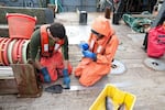 Fisheries observers Sean Sullivan and Virginia Taggert measure and record the size of fish. 