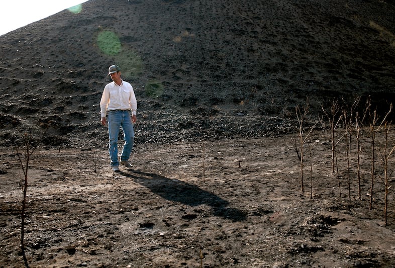 Jared Smull walks in a burned drainage at the end of his rangeland. Jared, a fifth generation rancher, says he has never experienced a burn of this scale. He anticipates it will take several years to recover.