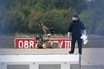 A forensic technician works alongside a bomb-disposal robot near a Ukrainian aircraft at Leipzig/Halle Airport, where a drone with an explosive device was found and a detonator was removed from the object, in Schkeuditz, Germany, Wednesday Aug. 5, 2026.