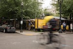 A bike whizzes by food pods on Southwest 10th Avenue and Alder Street in downtown Portland, Ore., on June 21, 2019. The pods must vacate the lot by the end of June to make room for a Ritz-Carlton.