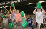 Participants tip buckets of ice water over their heads as they take part in the World Record Ice Bucket Challenge at Etihad Stadium on Aug. 22, 2014, in Melbourne, Australia.