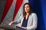 Judit Varga speaks at a press conference in 2022 while standing behind a lectern with two microphones attached to it.