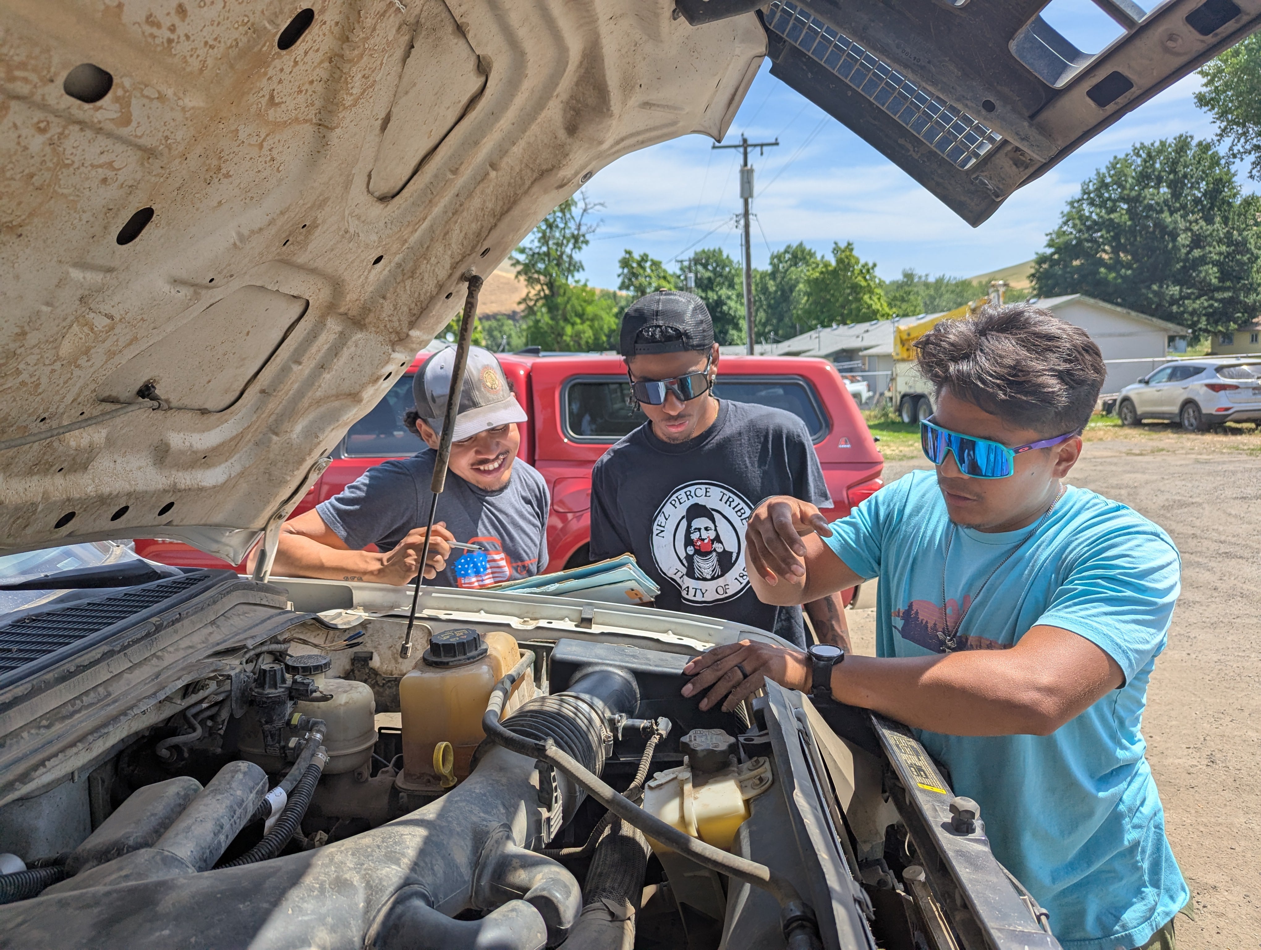 Jalisco Miles, left, holds a checklist while Farrell Hayes, middle, and Riston Bullock, right, check on the fire truck engine on June 12, 2025.