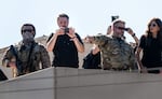 FILE - Conservative influencer Nick Sorter, center left, takes images from atop the U.S. Immigration and Customs Enforcement (ICE) facility on Oct. 7, 2025, during a visit by then-U.S. Homeland Security Secretary Kristi Noem. Some ICE officers wore face coverings.
