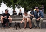 Suzanne Vinson (center) greets a pug while sitting with her dog Floyd.