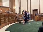 FILE - Washington state Supreme Court Justice Theo Angelis dons his robe alongside wife Kim and children Katherine and John as he is sworn in as a justice at the Temple of Justice on Monday, May 18, 2026, in Olympia.