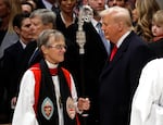 Bishop Mariann Edgar Budde (L) arrives as President Trump looks on during the National Prayer Service at Washington National Cathedral on Jan. 21, 2025 in Washington, DC.