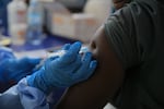 A health care worker administers a dose of Ervebo vaccine against the Ebola virus in Beni, North Kivu province, eastern Congo, on Oct. 16.